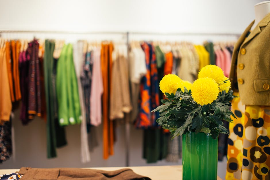 Collection of bright multicolored clothes hanging on rail in stylish boutique in daytime